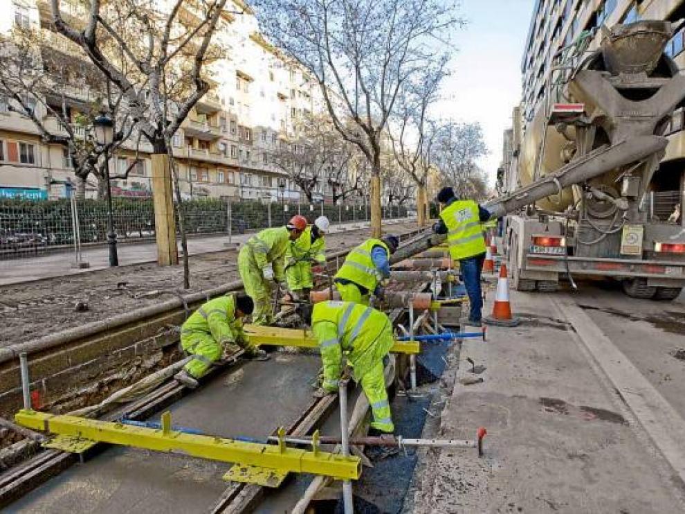La hormigonera vierte la capa definitiva bajo los carriles, ya colocados y fijados