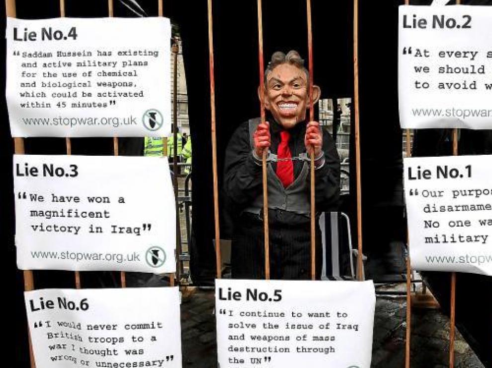 Un manifestante disfrazado de Tony Blair simula estar encerrado durante las protetas, ayer.