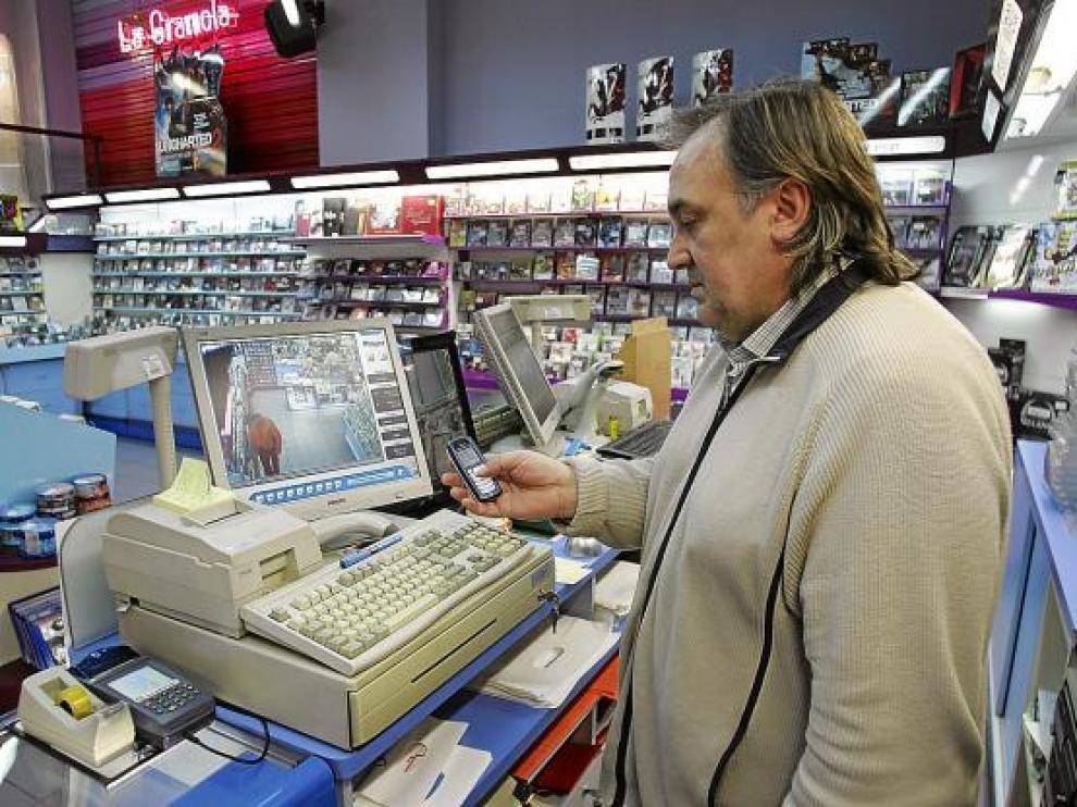 El propietario de La Gramola consulta el sistema de alerta a móviles en su establecimiento.