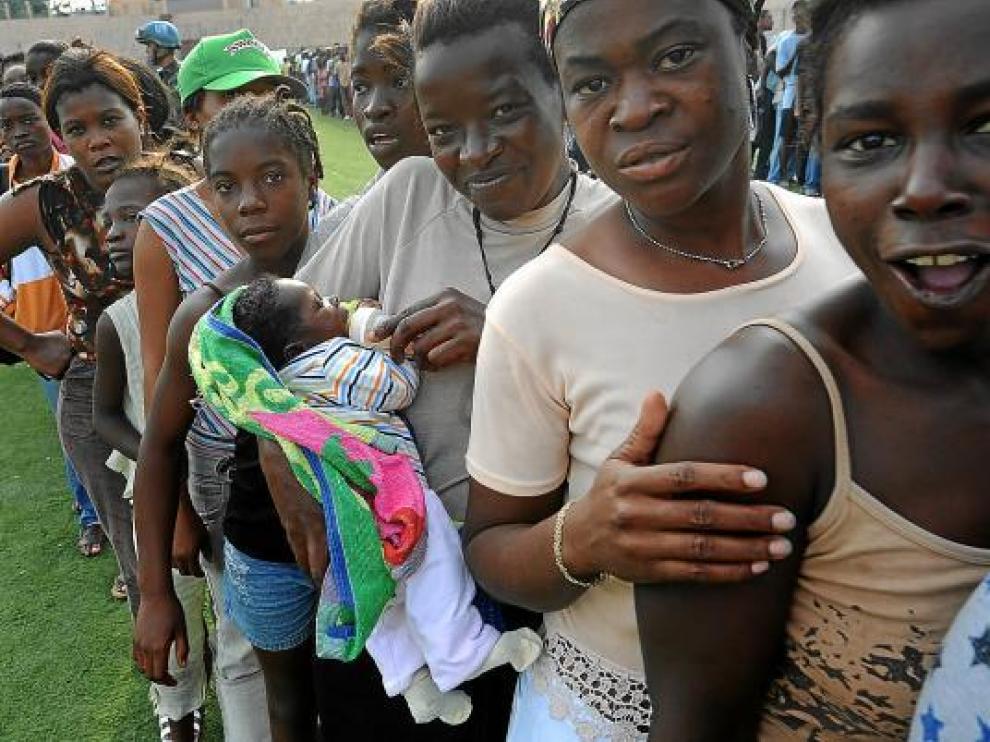 Mujeres y niños hacen cola en un punto de distribución de comida, ayer en Puerto Príncipe.