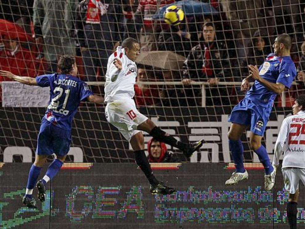El sevillista Luis Fabiano envía el balón a la red, ante la presencia de Cortés y Díaz.