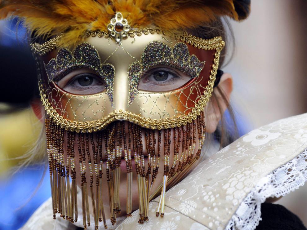 Una joven, ataviada con una delicada máscara de carnaval veneciana, en la plaza de San Marcos.