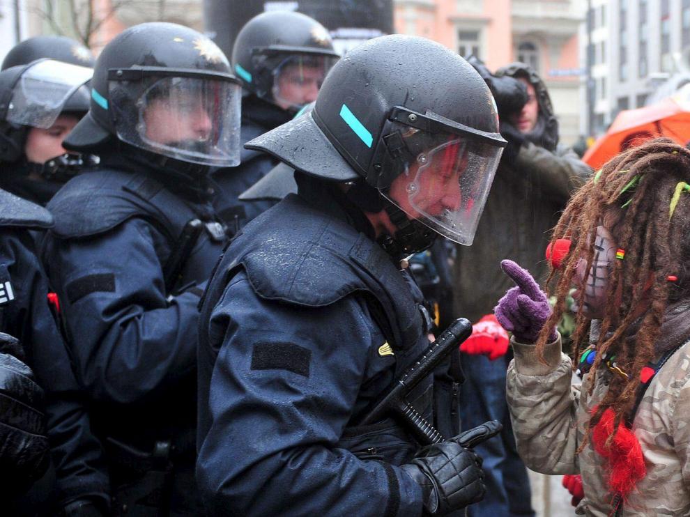 Una manifestante vestida de payasa regaña a un policía en una protesta contra la Conferencia de Seguridad, ayer en Múnich.