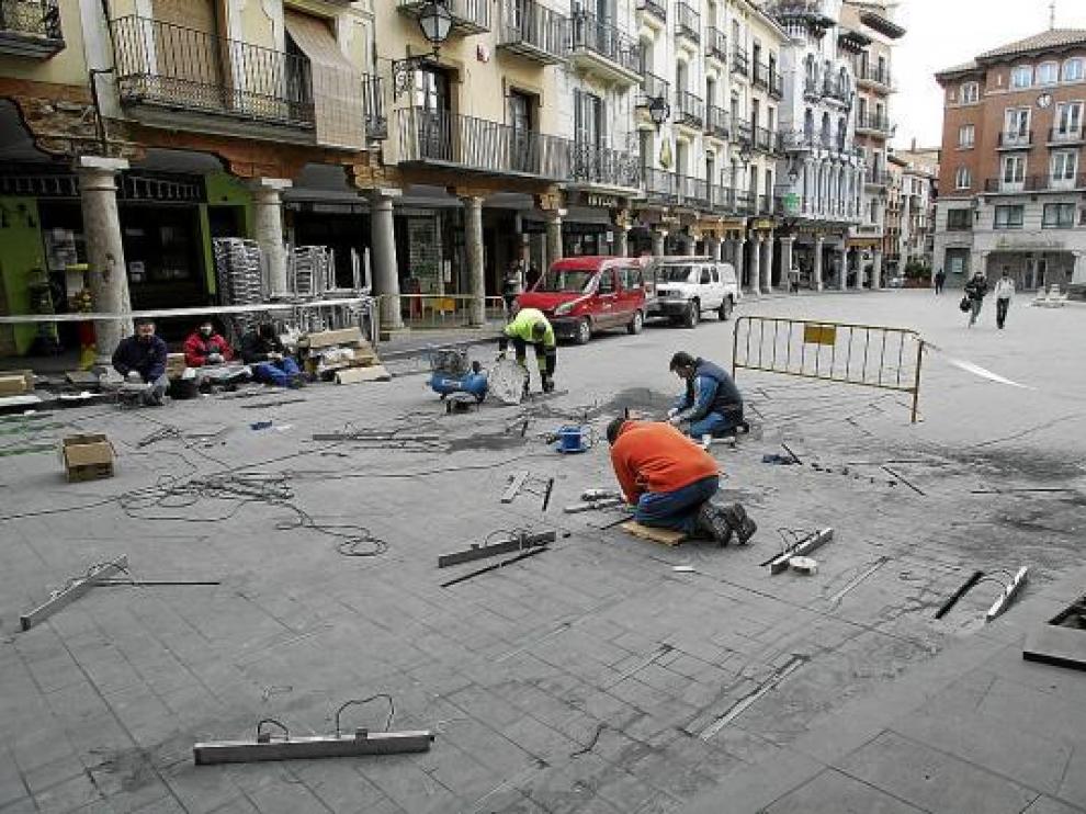 Operarios de Acciona trabajan en la sustitución de las luminarias averiadas de la plaza del Torico