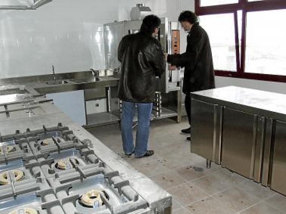 El alcalde (dcha.) y el secretario, en las cocinas del local.