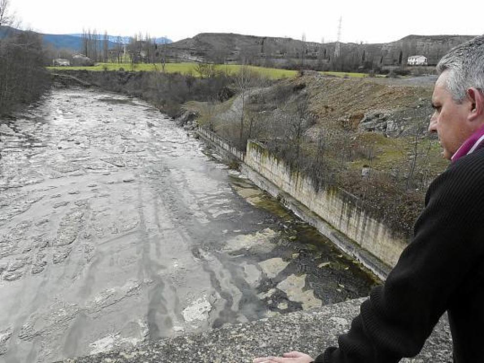 Miguel Ángel Sádaba observa el río Aragón a su paso por Jaca, que ayer llevaba más de agua.