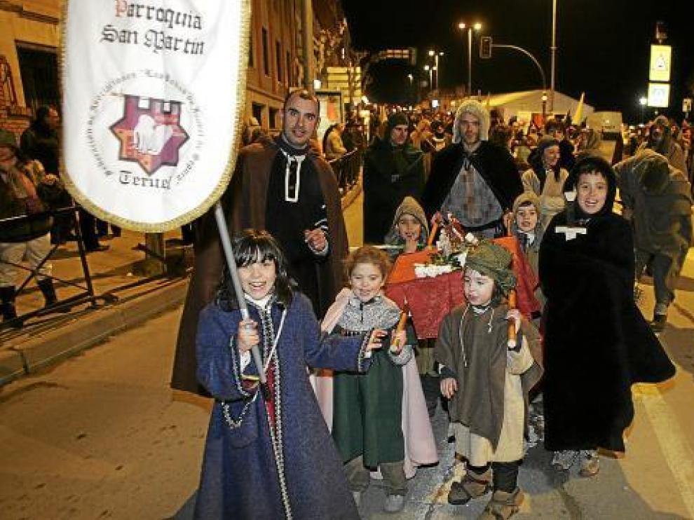 Un grupo de niños porta el estandarte de la parroquía medieval de San Martín