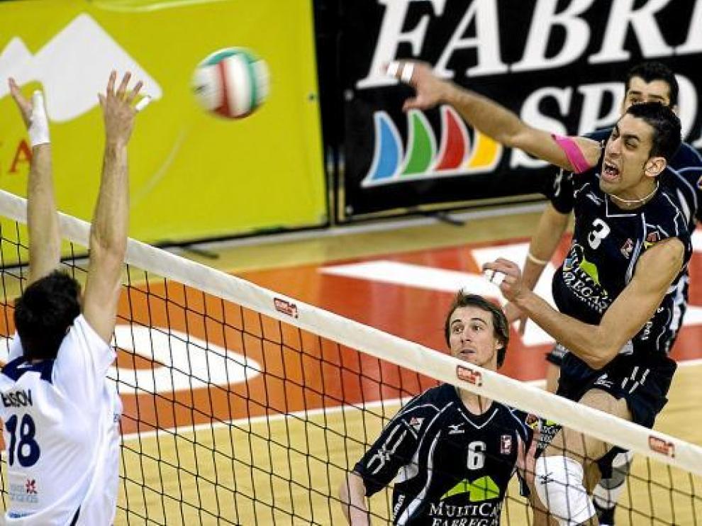 Fidalgo, jugador del Multicaja, remata en la red ante la mirada de Brian y la defensa de Belson