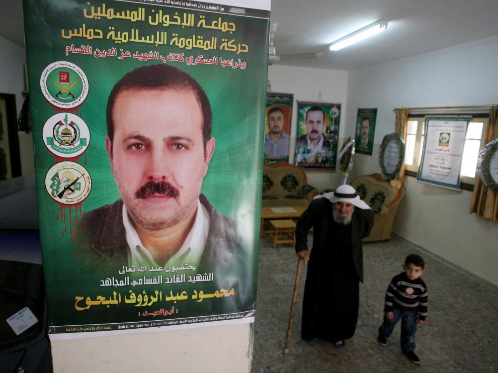 El padre y el nieto de Al Mabhuh pasan bajo un póster con su imagen en su casa de Jabalia, en el norte de la franja de Gaza, ayer