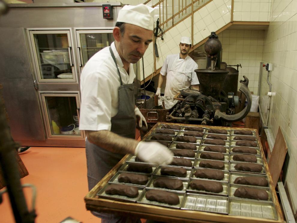 Algunos de los maestros pasteleros trabajan el chocolate en el obrador.