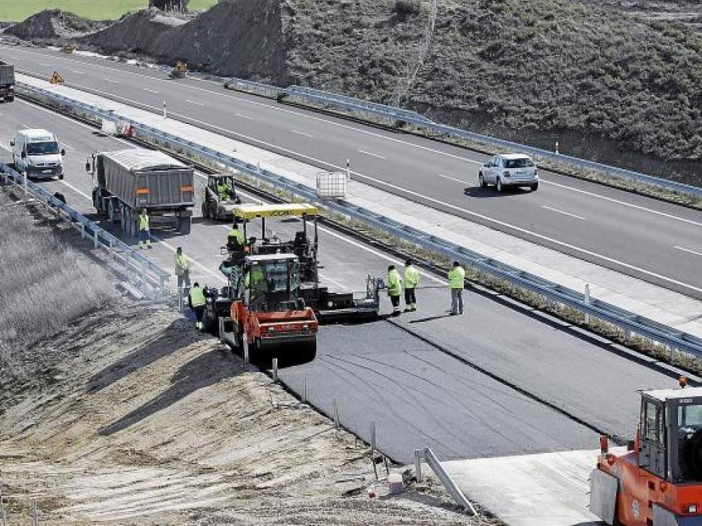 La empresa constructora reasfaltaba ayer la zona afectada por el hundimiento en sentido Huesca