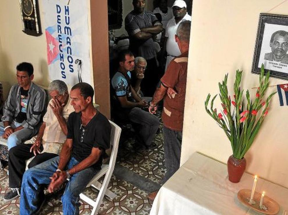 Opositores cubanos, ayer, en la casa de la líder de las Damas de Blanco junto a una foto de Zapata