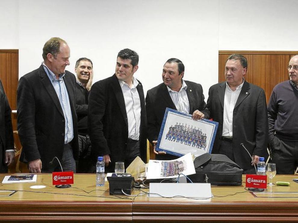El presidente entrante, Fernando Losfablos, entrega al saliente, Armando Borraz, un cuadro de recuerdo. Al lado, Agustín Lasaosa