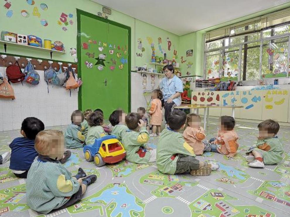 Un grupo de niños atienden a su profesora en una guardería de Zaragoza.