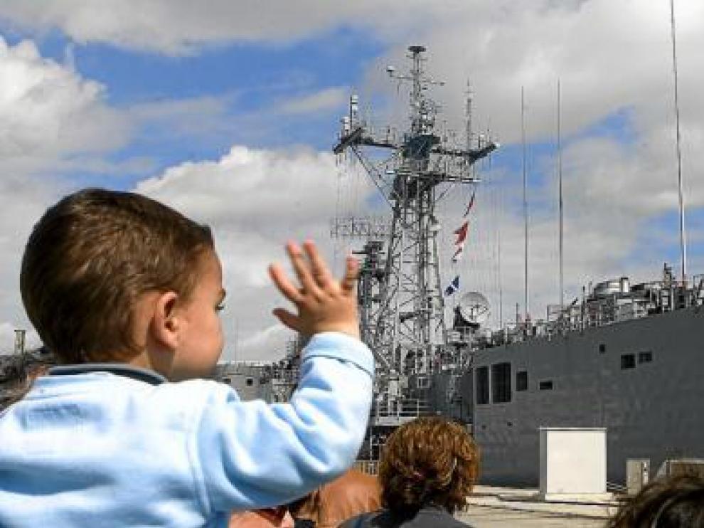 Un niño despide a la tripulación de la fragata 'Victoria', ayer, en la base gaditana de Rota.