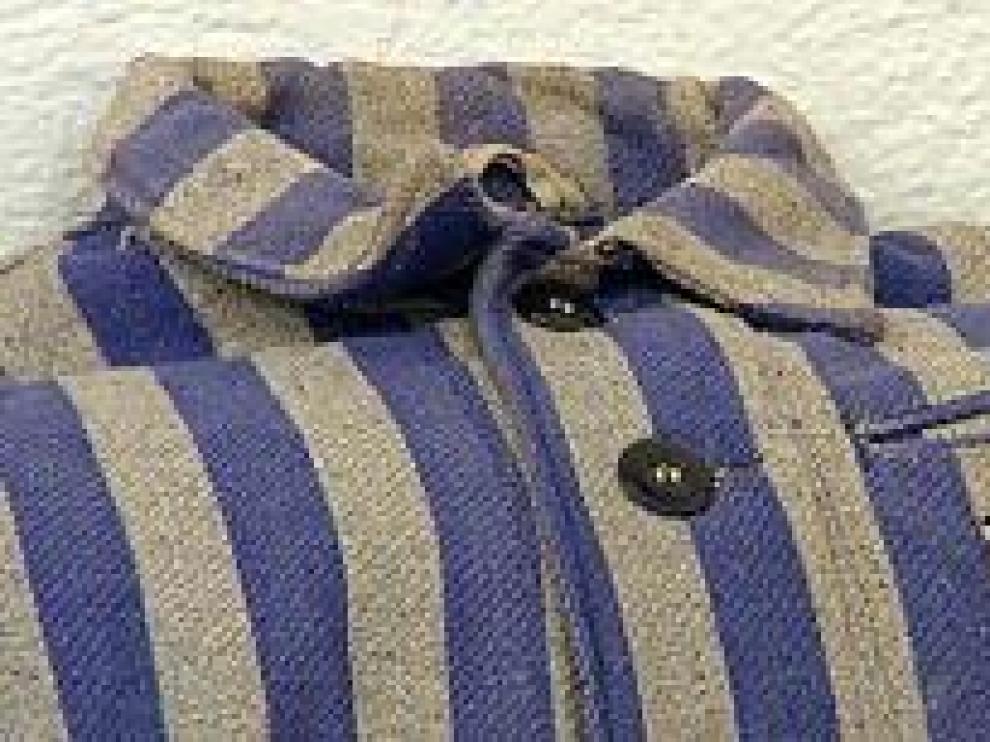 Un uniforme del campo de Mauthausen. Al lado, José Egea, hijo de un asesinado, con su nieta