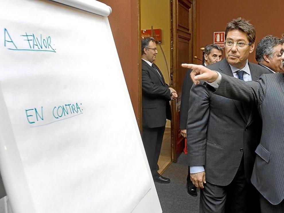 Manuel Teruel (izda.) y el consejero Arturo Aliaga, junto a la pizarra en la que se apuntó el resultado de la votación