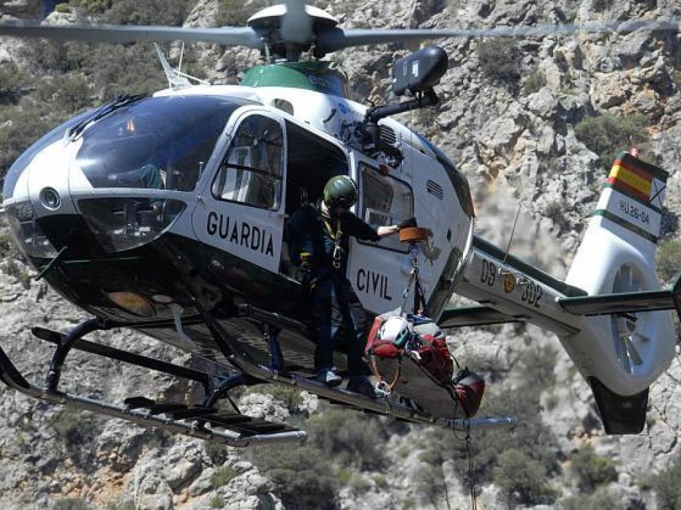 El herido, colocado en una camilla, fue evacuado en el helicóptero de la Guardia Civil.