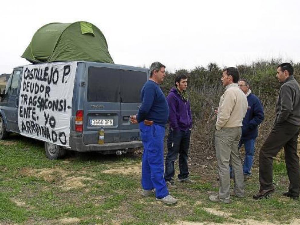 Dos representantes de Tragsa (derecha) conversan con tres de los afectados sobre su situación.