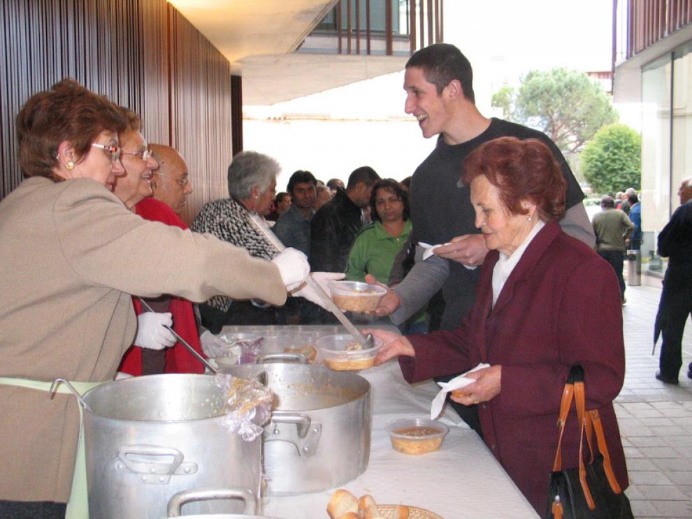 Varios vecinos recogen su ración de recao