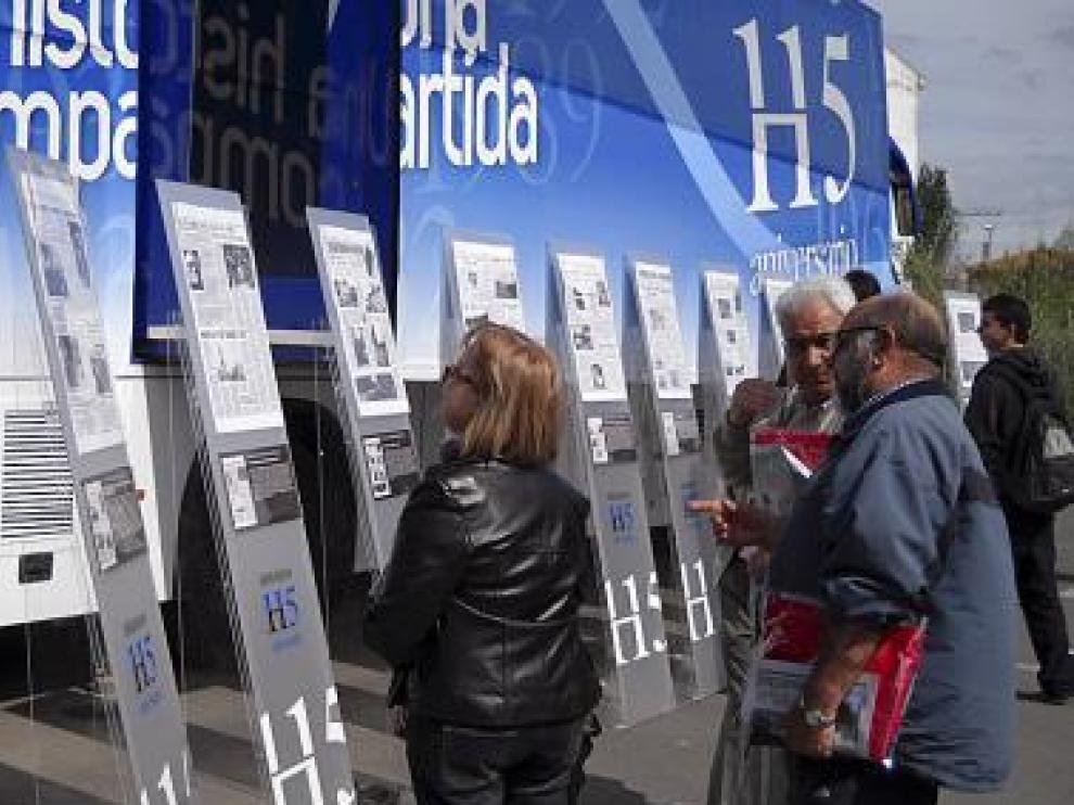 Varias personas observan los paneles con los periódicos.