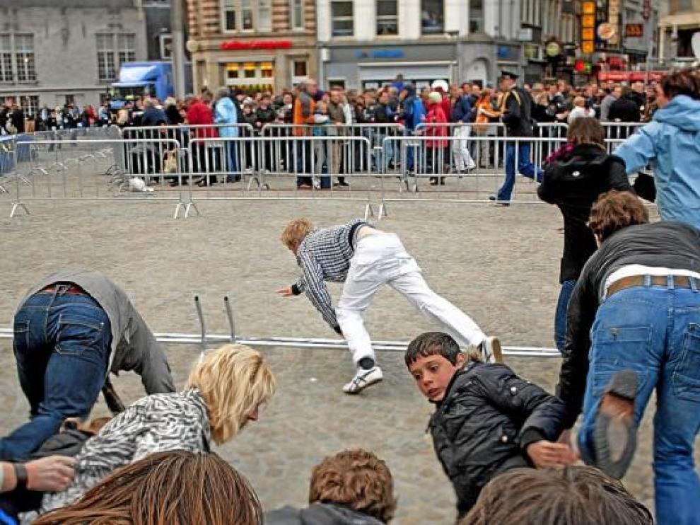 El público empieza a huir, con caídas en el camino, ante el pánico generado en la plaza Dam.