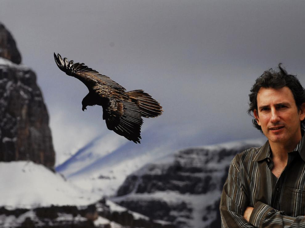 Andoni Canela delante de la foto de un quebrantahuesos del Pirineo