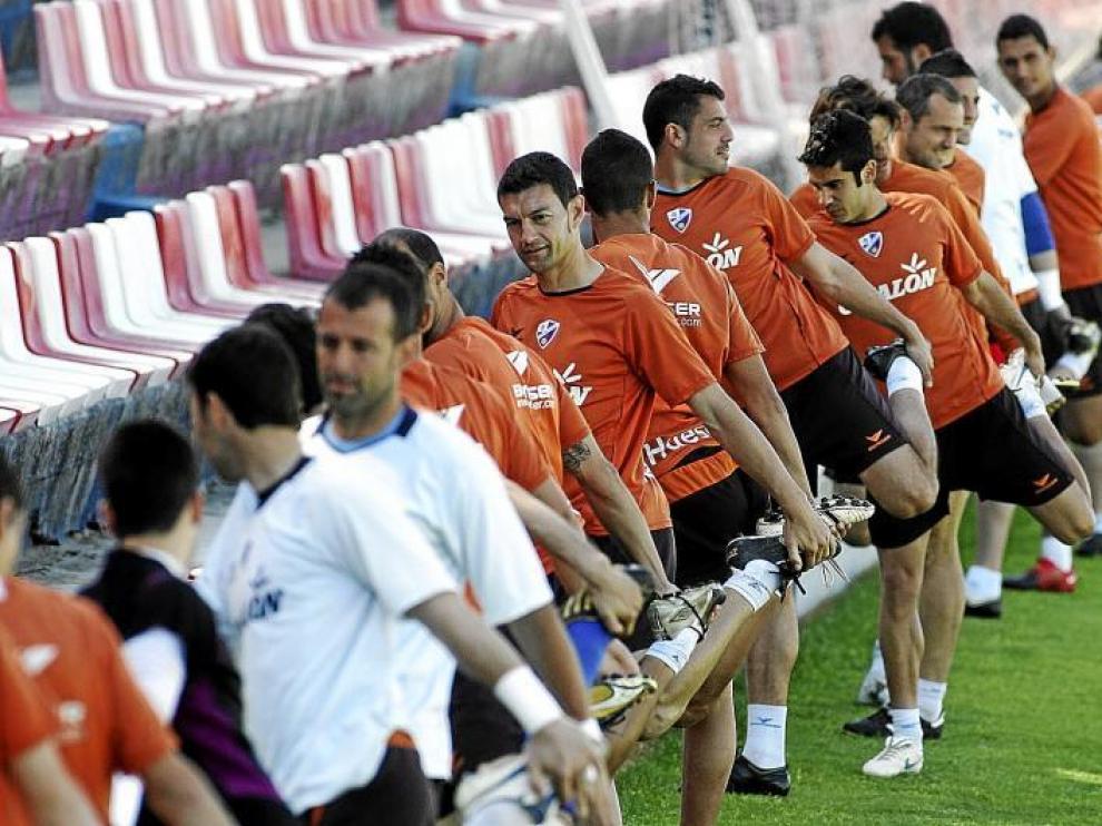 Los futbolistas del Huesca realizan estiramientos durante un entrenamiento en el estadio de El Alcoraz.