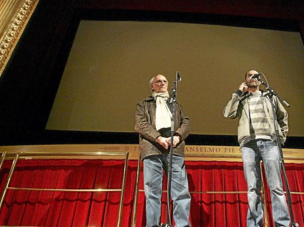 Carlos Saura, en el teatro Olimpia de Huesca, con el técnico de Cultura del Ayuntamiento Luis Lles.