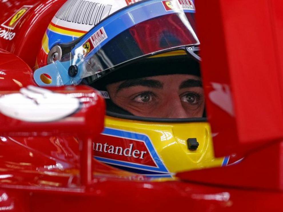 Fernando Alonso observa desde su Ferrari los tiempos de la tercera ronda de calificación.
