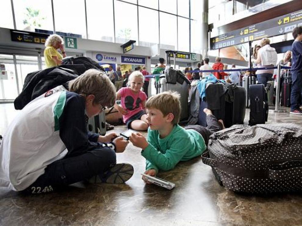 Varios niños se divierten con videojuegos en el aeropuerto de Tenerife.
