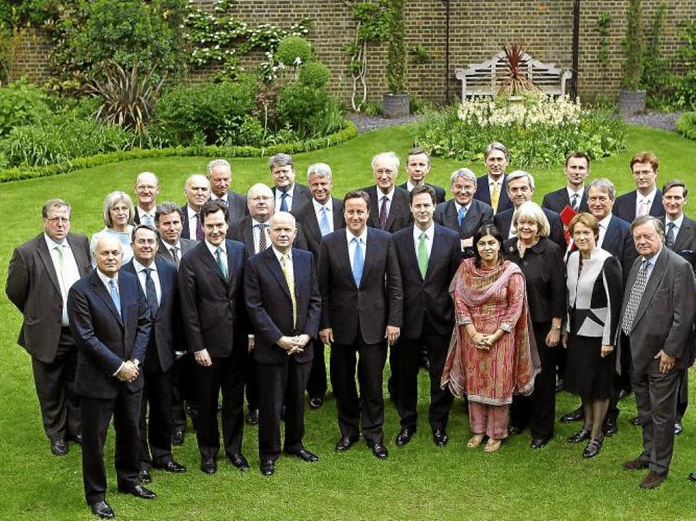 El nuevo Gobierno británico posa en el jardín de Downing Street, 10 con la presidenta de los conservadores, la baronesa Warsi.