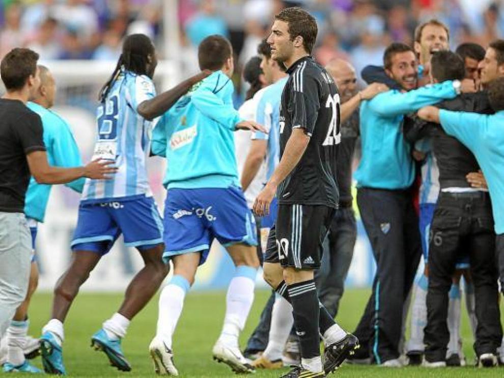Los jugadores del Málaga celebran la permanencia ante la decepción de Higuaín.