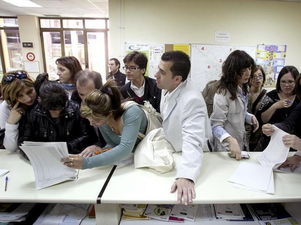 Los padres afectados por el proceso de escolarización consultaban ayer las listas para ver con el número que se ha asignado a sus hijos.