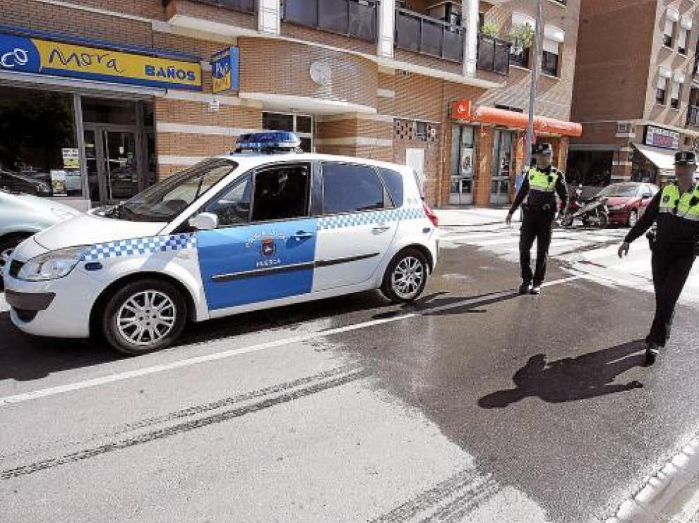 Dos policías locales, junto al paso de peatones donde fue arrollado ayer el matrimonio oscense.
