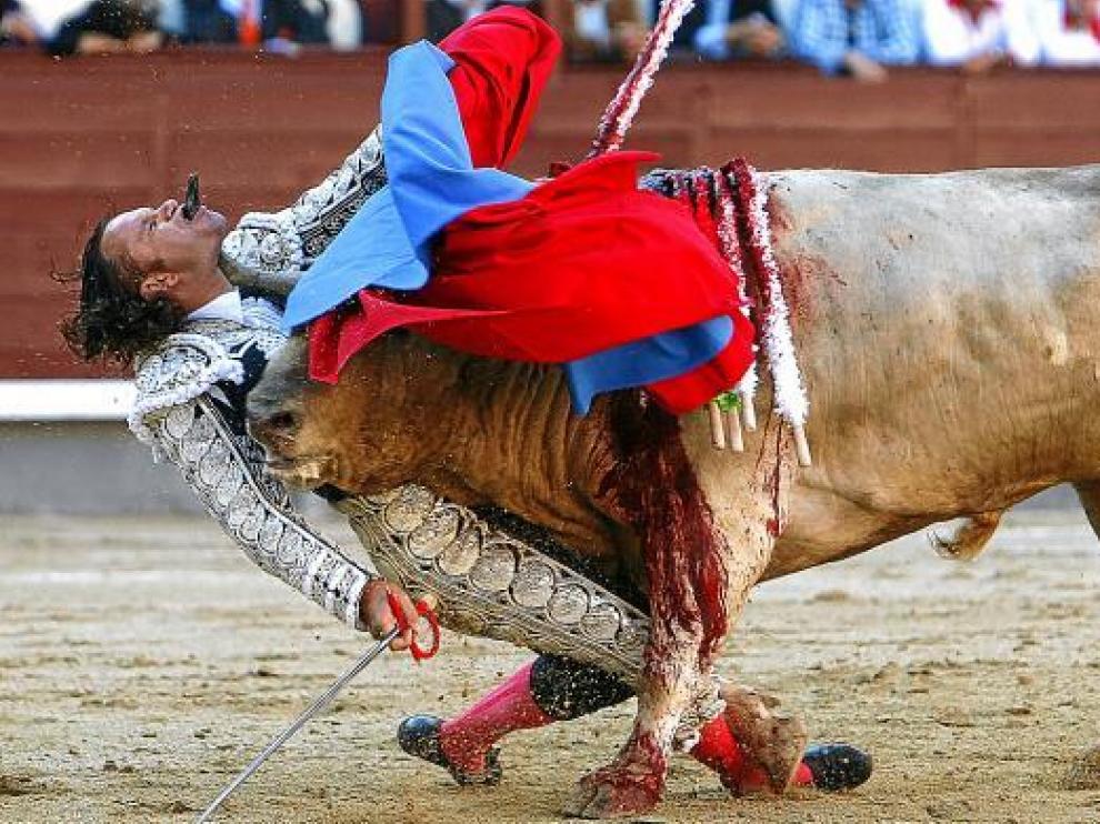 Julio Aparicio, en plena embestida del toro cuya cornada le atravesó el cuello ayer en Madrid.