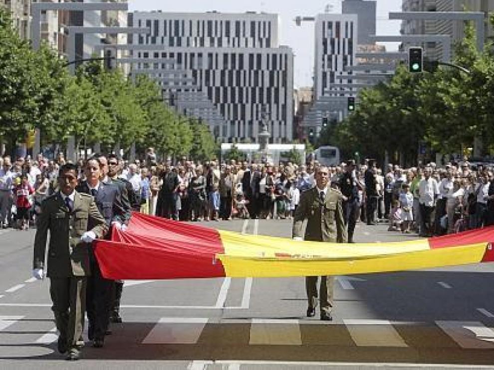 Los soldados portan la gran bandera que el Ministerio de Defensa donó al Ayuntamiento en 2008.