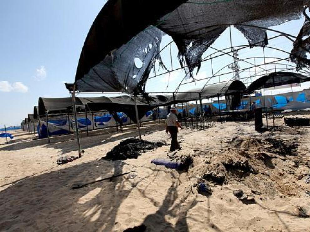 Un trabajador de la ONU inspecciona los restos del campamento quemado.