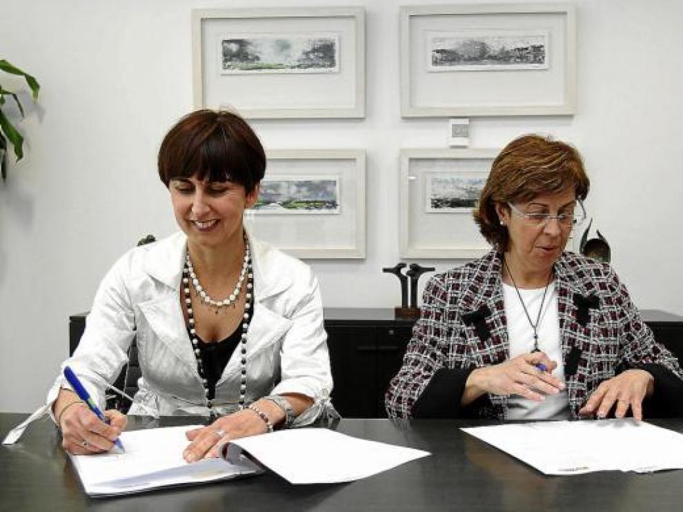 La directora general de Patrimonio del Estado, derecha, firma el traspaso con su homóloga de la DGA, ayer.