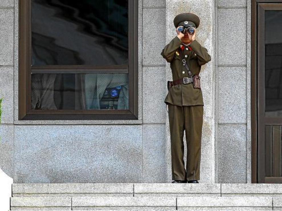 Un guardia norcoreano mira en dirección al sur a través de sus prismáticos, en la localidad fronteriza de Panmunjeom, ayer.