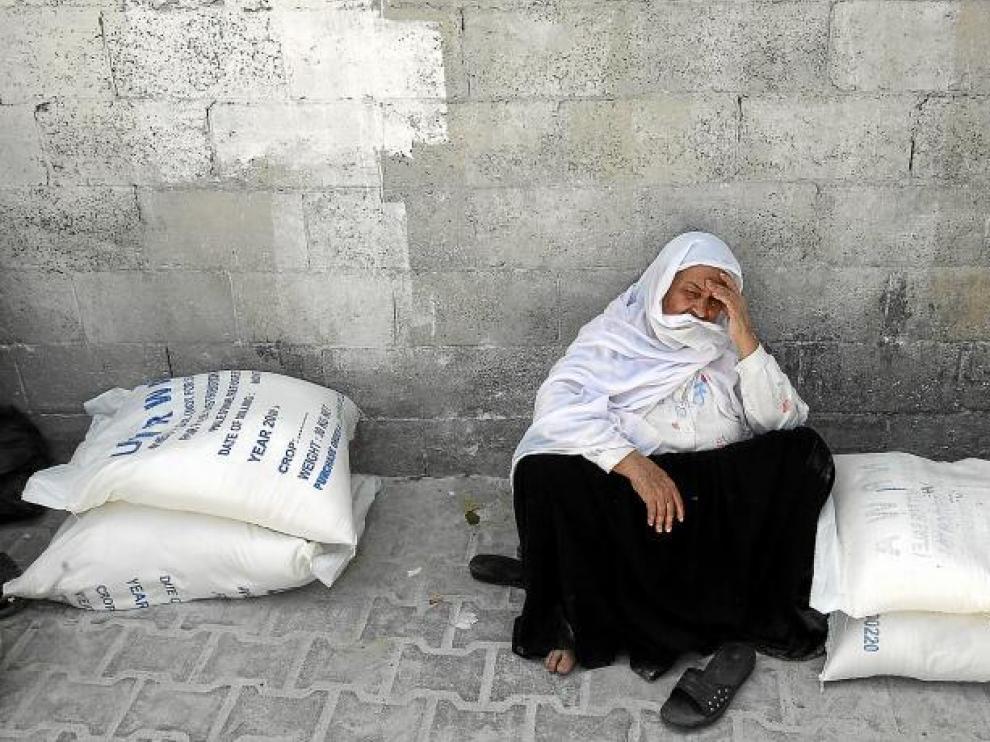 Una palestina esperaba ayer en Gaza a recibir comida de la Agencia de la ONU para los Refugiados de Palestina en Oriente Próximo.