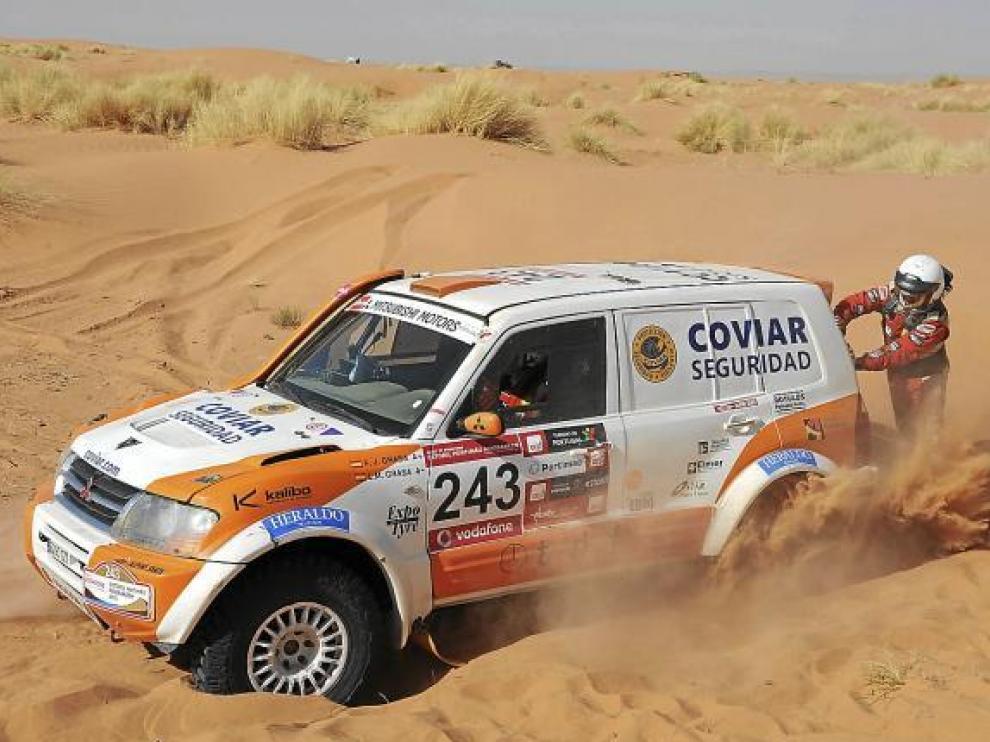 Miguel Grasa se esfuerza por ayudar a sacar el coche de un arenal en el desierto.