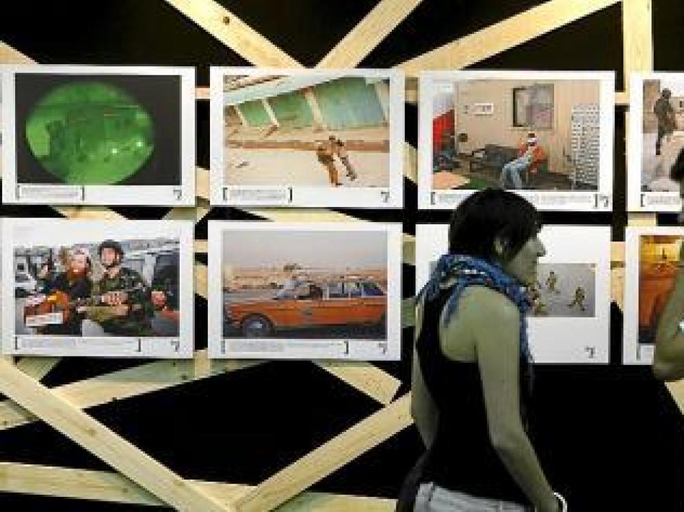 Dos jóvenes observan algunas de las fotos de la exposición.