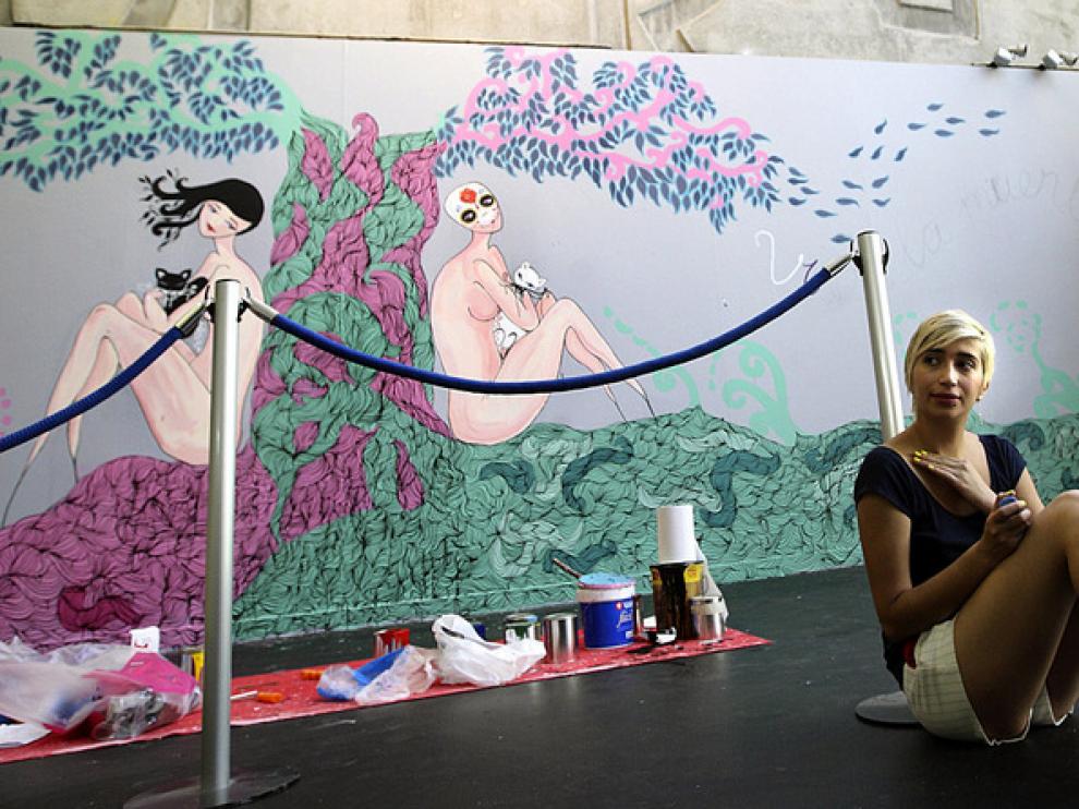 La artista urbana Vera junto a su obra.