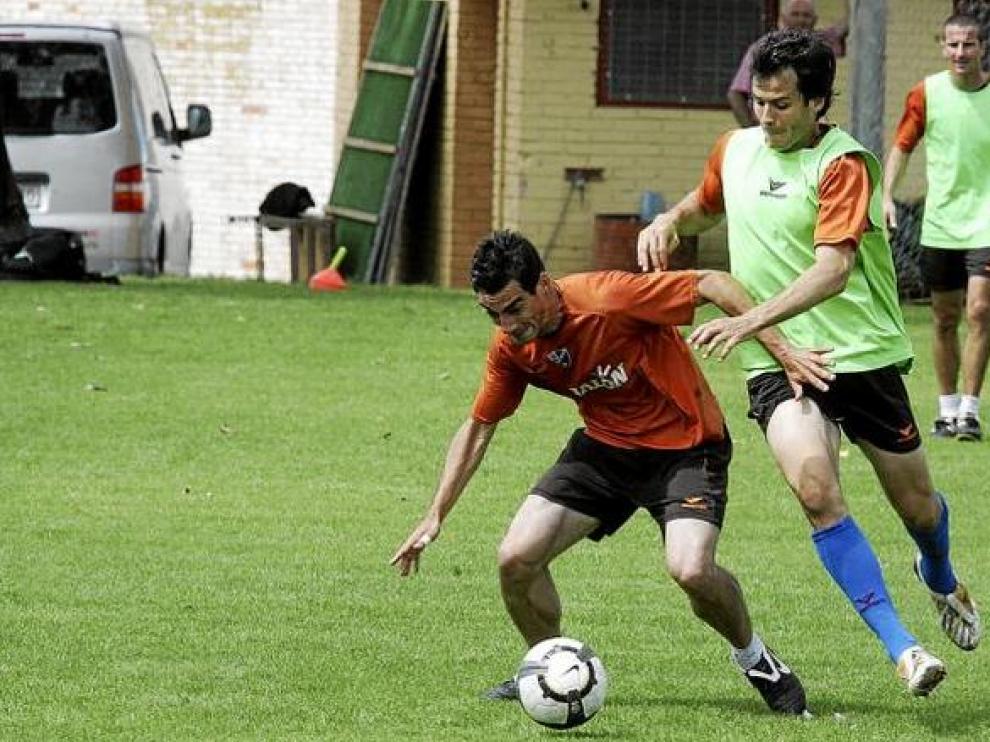 Vicente Pascual y Juanjo Camacho porfían por una pelota durante el entrenamiento de ayer por la mañana en el Instituto Montearagón.