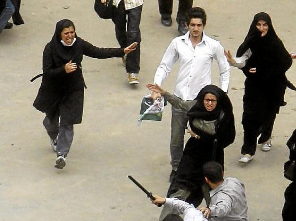 Policías vestidos de civil golpean a un manifestante en una protesta el 14 de junio de 2009 en Teherán.