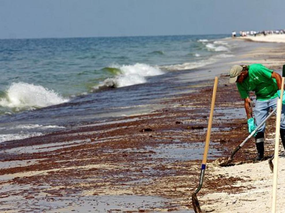 Un voluntario limpia las mancha de crudo en una playa de Gulf Shores, Alabama, ayer.