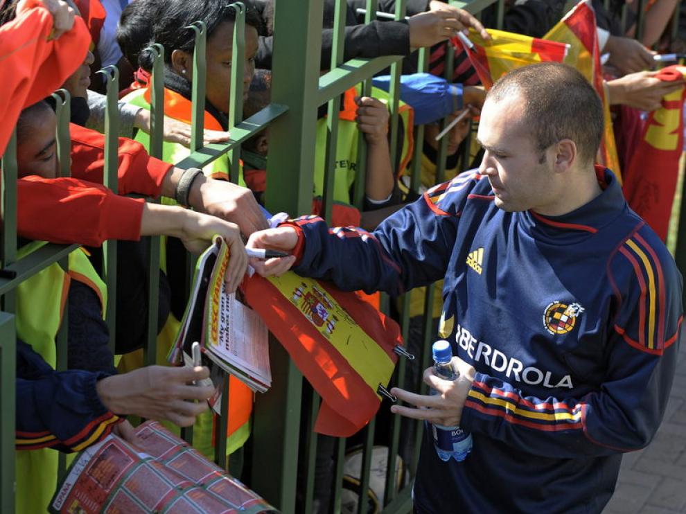 Iniesta firma autógrafos en la concentración de España