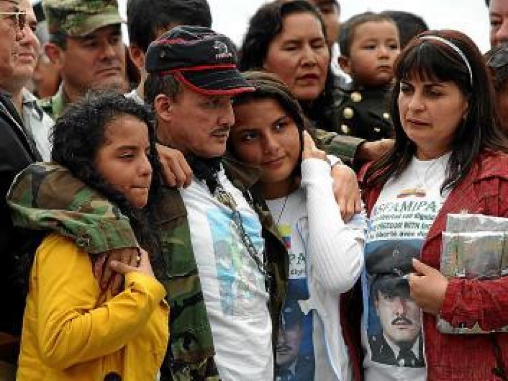 El sargento Delgado, aún con cadenas, abraza a su familia.