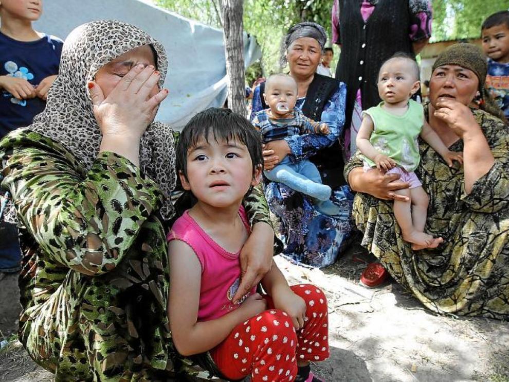 Refugiadas uzbekas con niños esperan en la frontera con Uzbekistán, a siete kilómetros del distrito uzbeko de Osh, ayer.